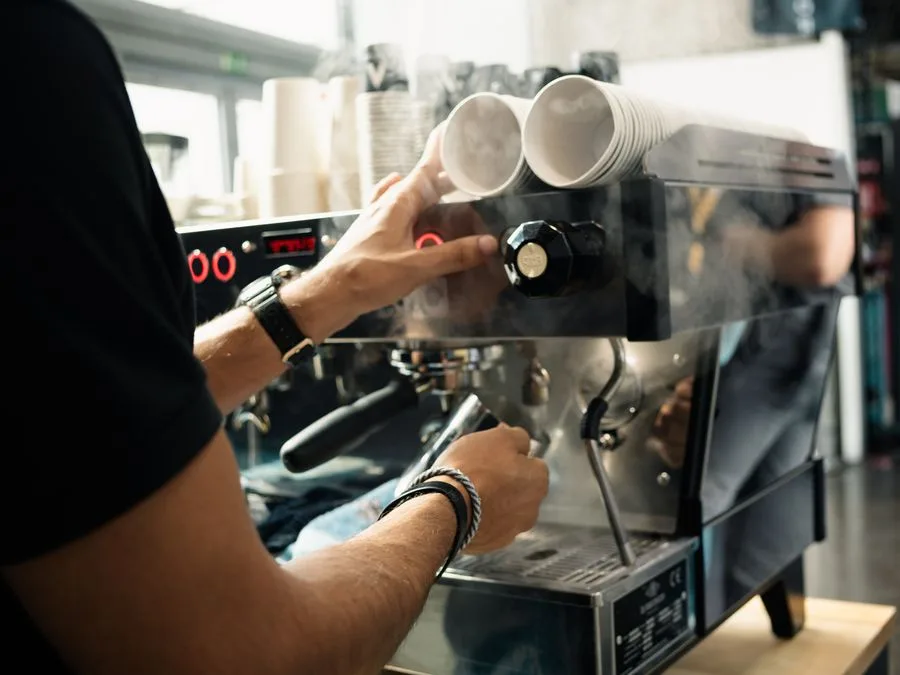 Barista pulling an espresso shot on a La Marzocco machine at a trade fair