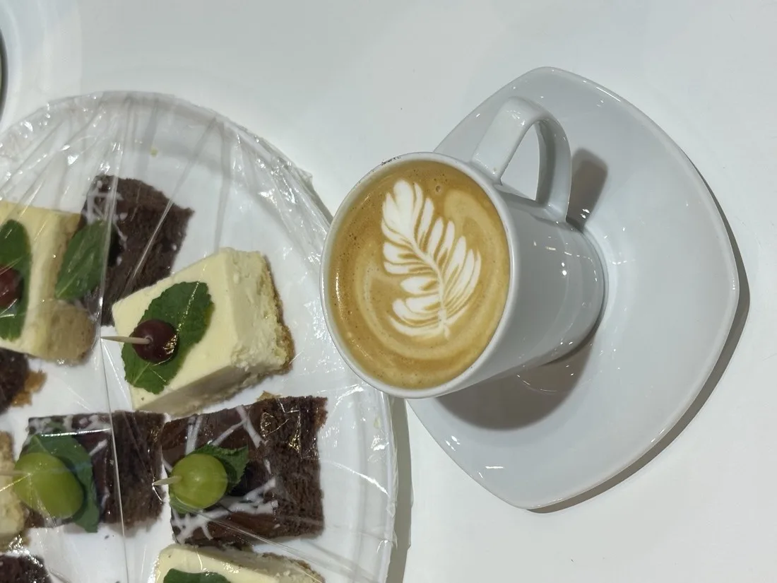 Cappuccino with latte art and breakfast sweets